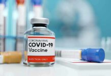COVID-19 vaccine vial with test tube on lab bench
