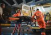 Emergency Oxygen Bus Helps Residents Breathe Paramedics load a patient on a stretcher into an ambulance at night