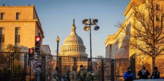National Guard troops stand at a security fence near the U.S. Capitol