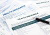 Close-up of health insurance application forms with a pen
