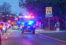 Emergency vehicles with flashing lights on a city street at night