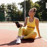 Legal Timebomb: WNBA’s Undefined Gatekeeper Woman in yellow activewear sitting on outdoor court with water bottle