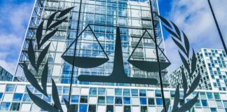 Scales of justice emblem on glass facade of modern office building