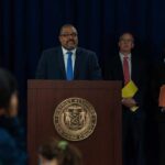 Campus Justice? 1,200 Cases – Almost Nobody Gone Man at podium during press conference with officials behind him