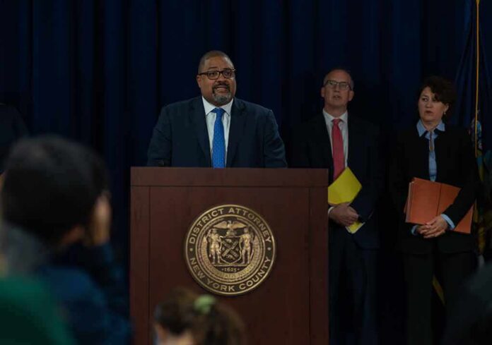 shutterstock_2199567217-2 Man at podium during press conference with officials behind him