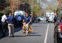 Police officers and investigators at a blocked city street scene