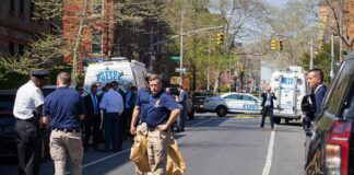 Police officers and investigators at a blocked city street scene