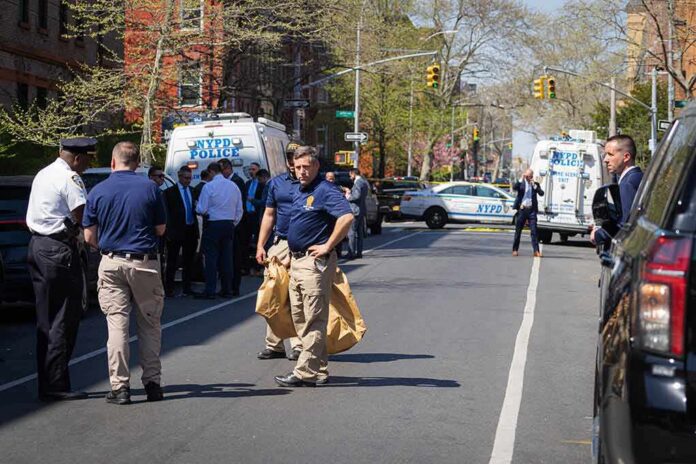 Police officers and investigators at a blocked city street scene