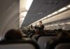 Flight attendant demonstrates safety procedures in airplane cabin