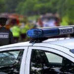 Elementary School Shooting Leaves 4 Dead Police car with blue light bar at roadside scene