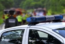 Police car with blue light bar at roadside scene