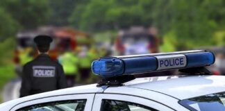 Police car with blue light bar at roadside scene