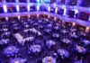 Ballroom filled with round tables at a formal gala dinner