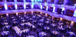 Ballroom filled with round tables at a formal gala dinner