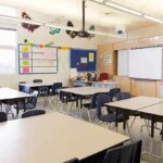 Bodycam Shock: Six-Year-Old Confesses Empty classroom with tables, chairs, and a whiteboard