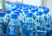 Plastic water bottles with blue caps in rows