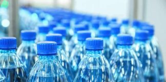 Plastic water bottles with blue caps in rows