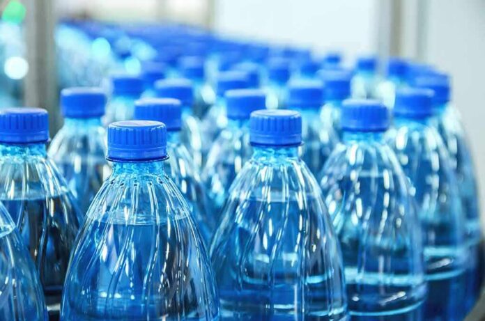 Plastic water bottles with blue caps in rows