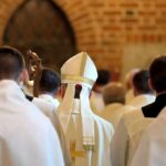 Priest’s Viral Moves Ignite Church Firestorm Bishop in white mitre among clergy during church procession