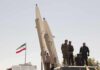 New Military Push Targets Iran-Backed Houthis Soldiers stand beside large missiles at an outdoor display