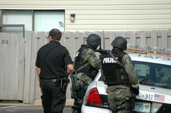 shutterstock_728435-1 police officers in tactical gear beside patrol car