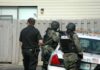 Horrific Erie Rampage Stuns Neighborhood police officers in tactical gear beside patrol car